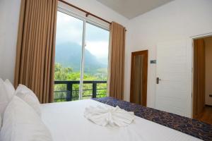 a bedroom with a bed and a large window at Visbury Villa in Gangaboda