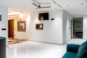 a living room with a couch and a ceiling fan at Hotel Panipat Prime in Pānīpat
