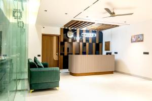 a lobby with a green chair and a reception desk at Hotel Panipat Prime in Pānīpat