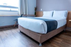 a large bed in a room with a window at ExpoStay Hotel Corferias Embajada Americana in Bogotá