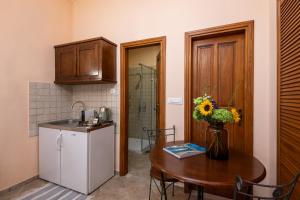 a kitchen with a table with a vase of flowers on it at Antaeus Old Town Residence in Dubrovnik +37 photos