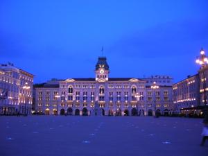 a large building with a clock tower at night at Torrebianca in Trieste