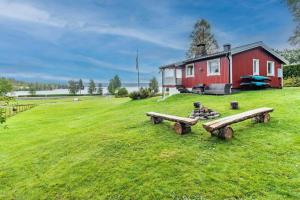 a red house with two benches in front of it at VAR101-Arjaeng in Årjäng