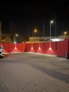 a parking lot with a red wall at night at Teplice Apartments in Teplice