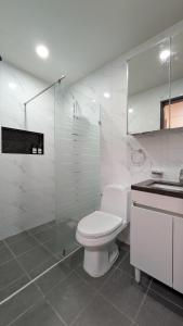 a white bathroom with a toilet and a sink at Cozy Clark Stay 3BR Condo in Clark +32 photos