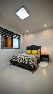 a bedroom with a bed with yellow pillows and a window at Cozy Clark Stay 3BR Condo in Clark