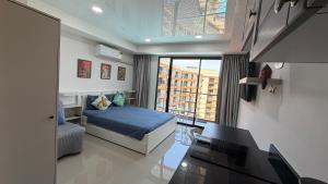a small bedroom with a bed and a balcony at Mai Khao 777 Beach Condo in Ban Mai Salae