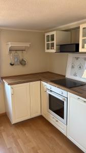 a kitchen with white cabinets and a stove top oven at Heimelige Wohnung Bei der Stoffschmiede in Schutterwald
