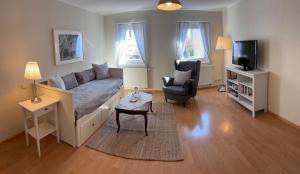 a living room with a couch and a tv at Heimelige Wohnung Bei der Stoffschmiede in Schutterwald