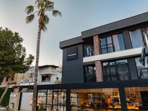 a building with a palm tree in front of it at Nivasole Lara Pure Comfort & Style in Antalya