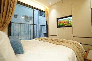 a bedroom with a bed and a tv on a wall at Hanoi Aurelia Stay in Hanoi