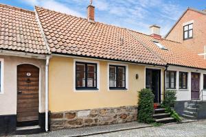 a yellow house with an orange roof at SKA117-Simrisham-Skepparegatan-6 in Simrishamn