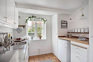 a white kitchen with a window and a sink at SKA117-Simrisham-Skepparegatan-6 in Simrishamn