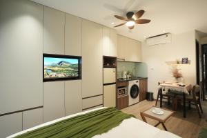 a bedroom with a bed and a kitchen with a table at Hanoi Aurelia Stay in Hanoi