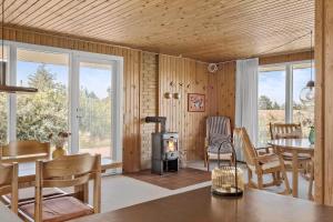 a living room with a fireplace and a table and chairs at 20315-Samso-Rosenvej-42 in Tanderup