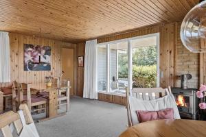a dining room with a table and a fireplace at 20315-Samso-Rosenvej-42 in Tanderup +24 photos