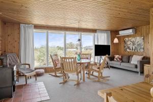 a living room with a table and chairs and a couch at 20315-Samso-Rosenvej-42 in Tanderup