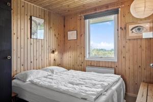 a bedroom with a bed in a wooden wall at 20315-Samso-Rosenvej-42 in Tanderup
