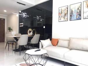 a living room with a white couch and a table at Căn hộ 2PN THE EMERALD GOLF VIEW in Thuan An