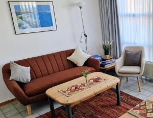 a living room with a brown couch and a table at Ferienwohnung Stoetera in Malente