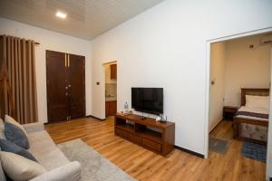 a living room with a couch and a flat screen tv at Visbury Villa in Gangaboda