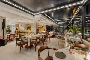 a restaurant with white tables and chairs and windows at Nivasole Lara Pure Comfort & Style in Antalya