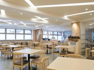 a dining room with tables and chairs and windows at ALA HOTEL KYOTO in Kyoto