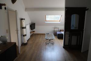 a living room with a table on a hard wood floor at Pause-toit, Le gîte de Mozet. in Gesves