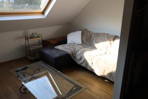 a living room with a couch and a glass table at Pause-toit, Le gîte de Mozet. in Gesves