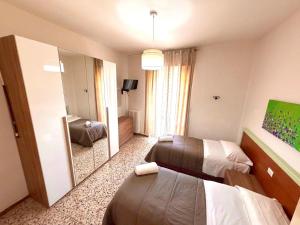 a hotel room with two beds and a mirror at Hotel San Donnino in Fidenza +15 photos