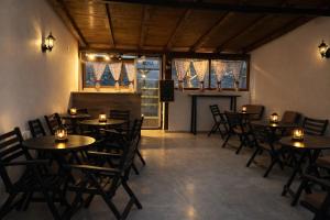 a restaurant with tables and chairs and a fireplace at Karali Apartments in Lagadin