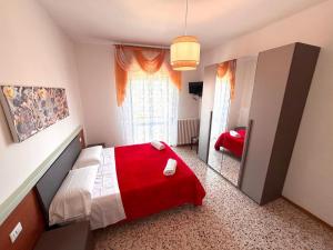 a bedroom with a red and white bed and a mirror at Hotel San Donnino in Fidenza