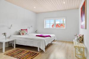 a white bedroom with a bed and a window at 20124-Samso-Maarup-Havn-3 in Nordby