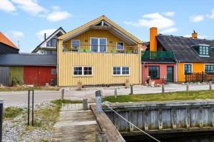 a yellow house next to a river with buildings at 20124-Samso-Maarup-Havn-3 in Nordby