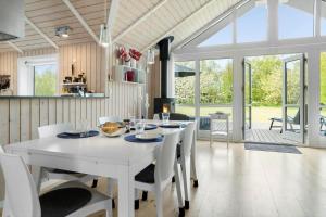 a dining room with a white table and chairs at 20134-Samso-Heden-19 in Nordby +22 photos