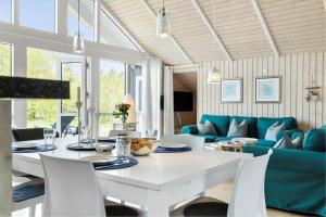a dining room with a white table and a blue couch at 20134-Samso-Heden-19 in Nordby