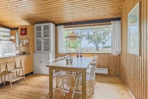 a kitchen with a table and chairs and a window at 20119-Samso-Maarup-Skov-26 in Nordby