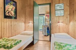 a bedroom with two beds in a wooden wall at 20119-Samso-Maarup-Skov-26 in Nordby