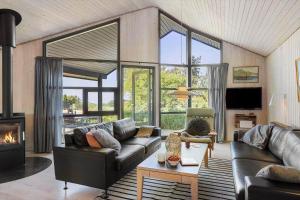 a living room with a couch and a fireplace at 20220-Samso-Rosenvej-25 in Tanderup