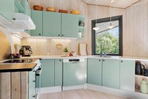 a kitchen with blue cabinets and a window at 20220-Samso-Rosenvej-25 in Tanderup +23 photos