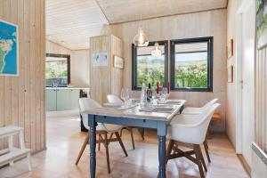a dining room with a blue table and white chairs at 20220-Samso-Rosenvej-25 in Tanderup