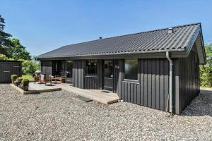 a black shed with a deck and a patio at 20220-Samso-Rosenvej-25 in Tanderup