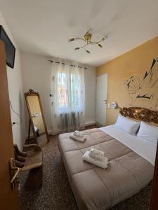 a bedroom with a large bed with towels on it at Experience Hotel Antico Capon in Venice
