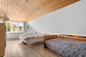 a bedroom with two beds and a wooden ceiling at 20120-Samso-Nordby-Hovedgade-22 in Nordby
