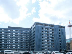 a large building with cars parked in a parking lot at ALA HOTEL KYOTO in Kyoto
