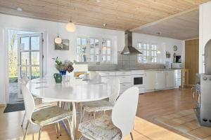a kitchen with a white table and chairs in it at 20616-Samso-Norreskiftevej-40 in Brundbymark