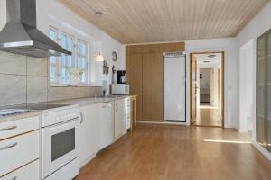 a kitchen with white appliances and a wooden ceiling at 20616-Samso-Norreskiftevej-40 in Brundbymark +34 photos
