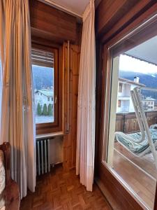 a room with a large window and a ladder at Calvi's Center Home in Auronzo di Cadore