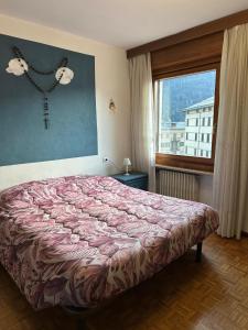a bedroom with a bed and a window at Calvi's Center Home in Auronzo di Cadore