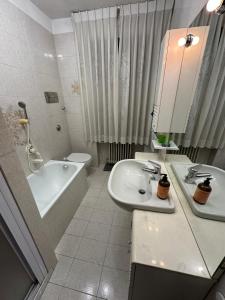 a bathroom with a sink and a tub and a toilet at Calvi's Center Home in Auronzo di Cadore +14 photos